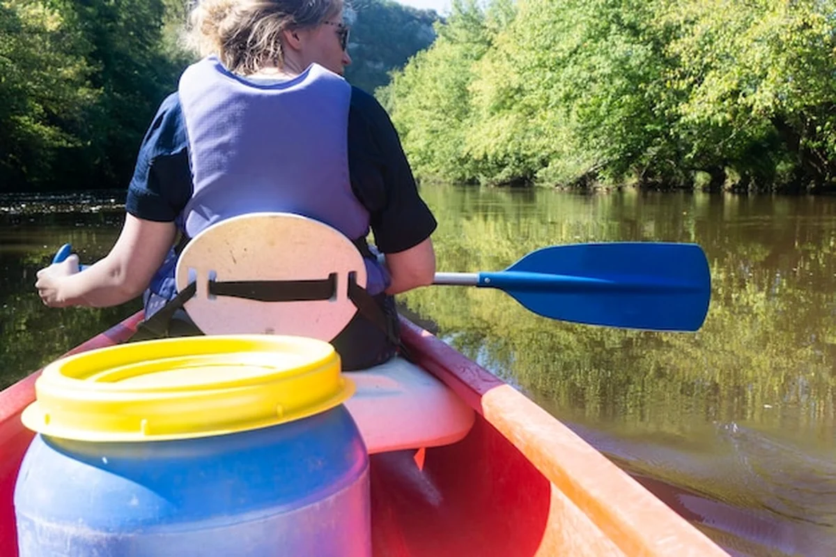 Mężczyzna trzymający łódź w jeziorze przeciwko drzewom