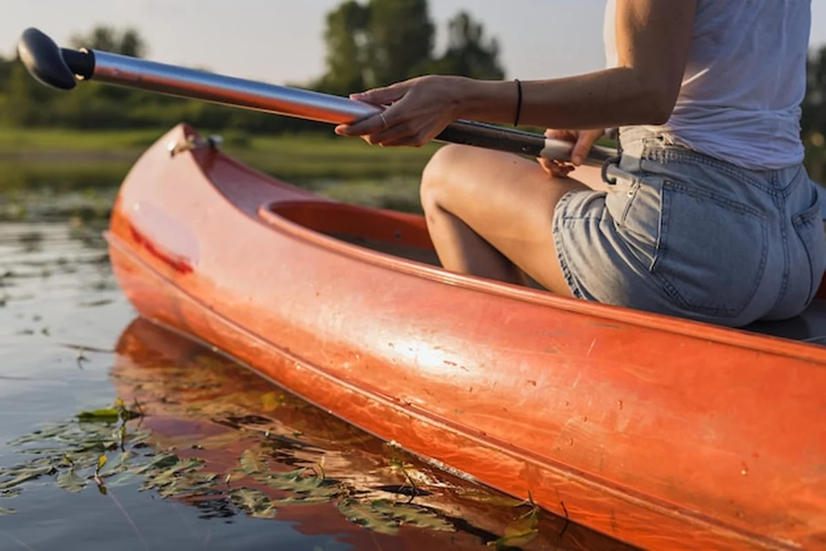 Kobieta w kajaku na jeziorze w letni dzień